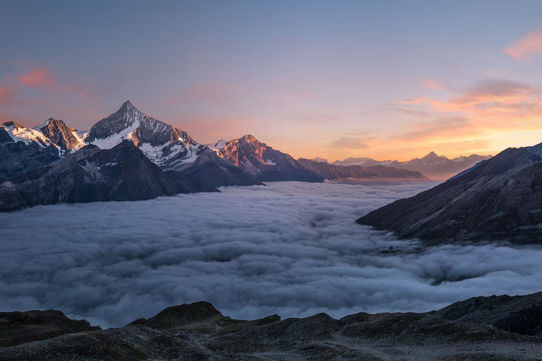 Mountain peaks rising above low cloud at sunrise in British Columbia
